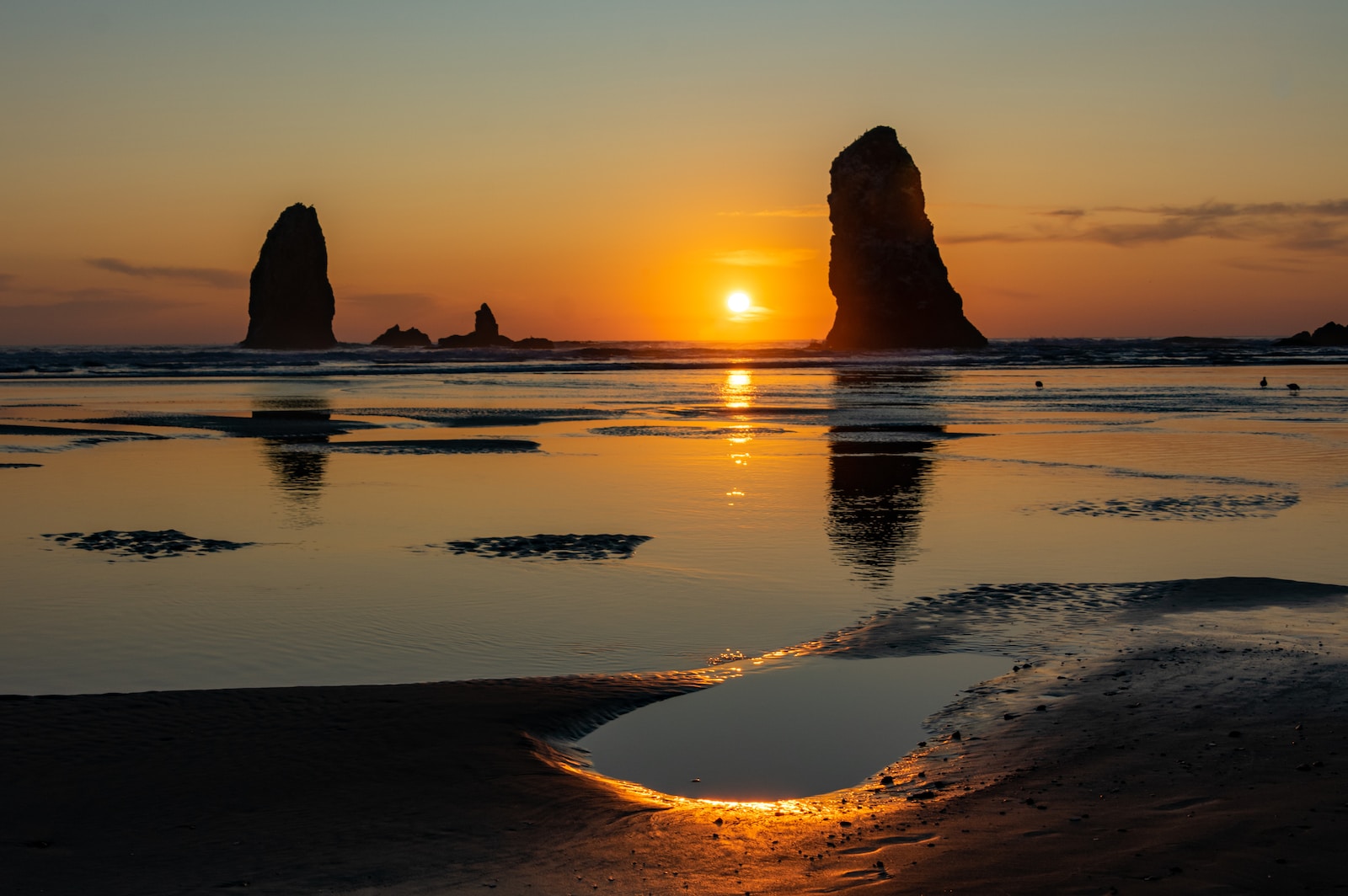 Informacja o konsultacji the sun is setting over the ocean with rocks in the background